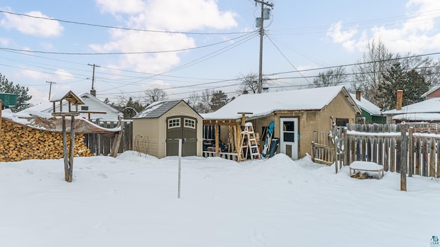 snowy yard featuring a shed