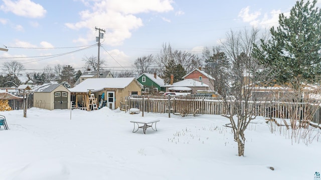 yard layered in snow featuring a shed