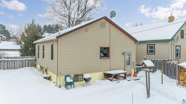 view of snow covered back of property