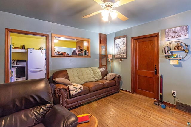 living room with ceiling fan and light hardwood / wood-style flooring