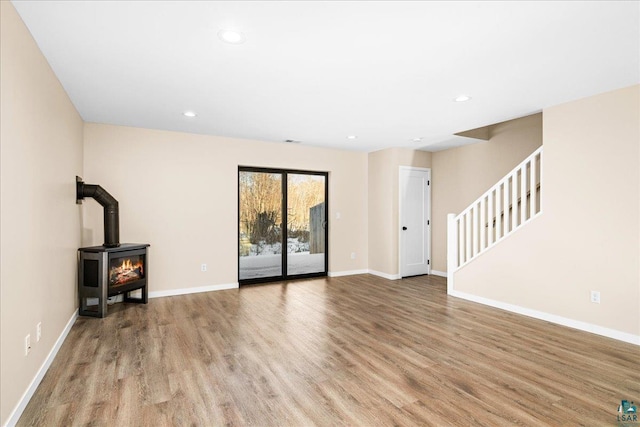 unfurnished living room featuring light wood-type flooring and a wood stove