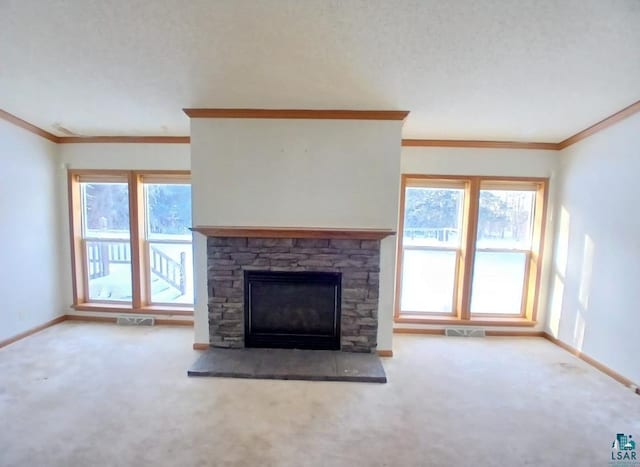 unfurnished living room with crown molding, plenty of natural light, carpet floors, and a fireplace