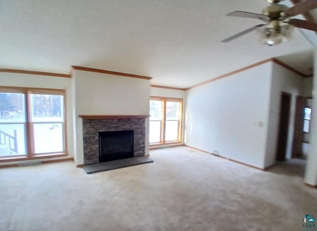 unfurnished living room with ceiling fan, ornamental molding, a fireplace, and light carpet