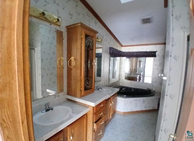 bathroom featuring lofted ceiling, ornamental molding, vanity, and a tub