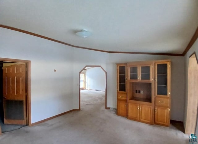 unfurnished living room with crown molding and light colored carpet