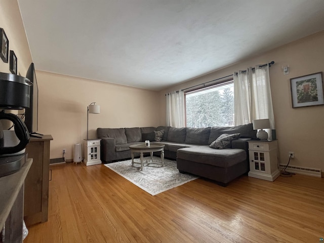 living room with baseboard heating and light hardwood / wood-style flooring