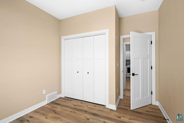 unfurnished bedroom featuring wood-type flooring and a closet