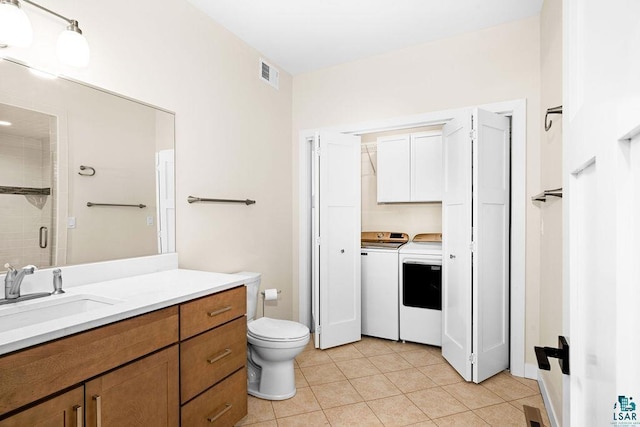 bathroom featuring toilet, an enclosed shower, vanity, independent washer and dryer, and tile patterned flooring