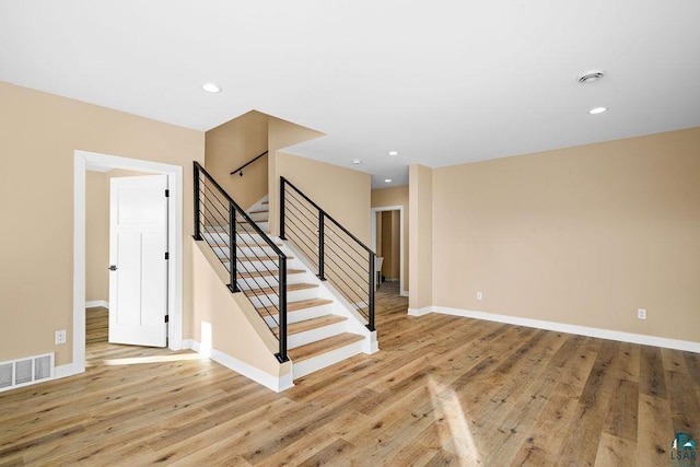 staircase with hardwood / wood-style floors