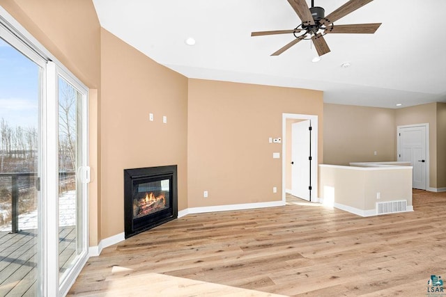 unfurnished living room featuring ceiling fan, vaulted ceiling, and light hardwood / wood-style floors