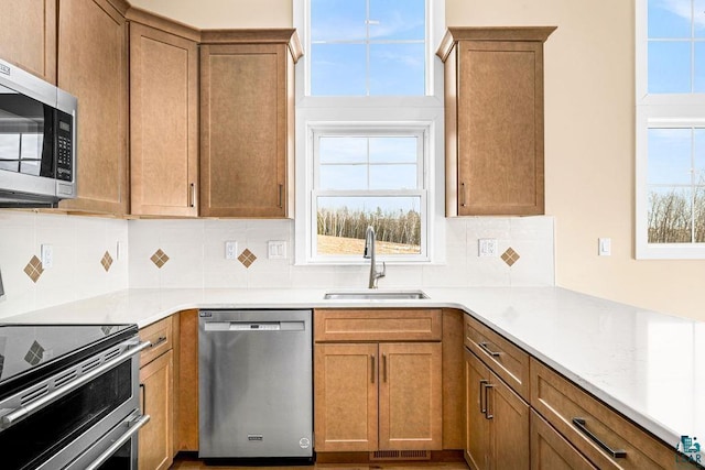 kitchen with appliances with stainless steel finishes, sink, and backsplash