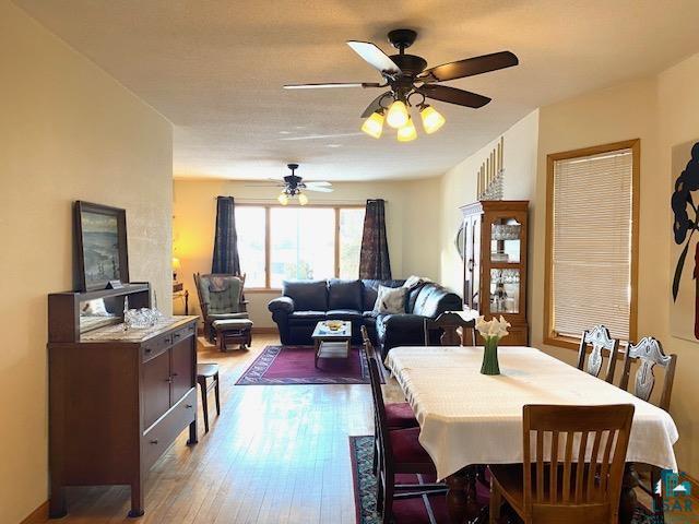 dining area with hardwood / wood-style floors and ceiling fan