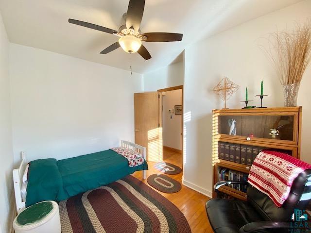 bedroom with ceiling fan and light wood-type flooring