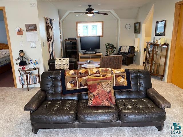 carpeted living room with ceiling fan