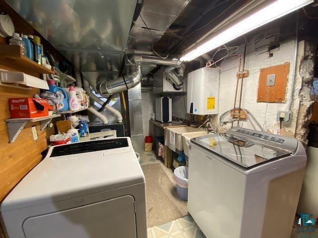 clothes washing area featuring water heater