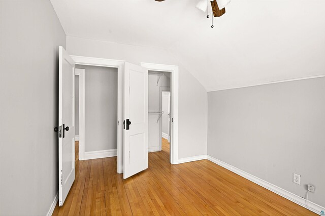 unfurnished bedroom featuring vaulted ceiling, ceiling fan, and light wood-type flooring