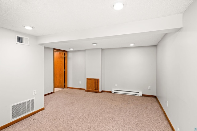 basement featuring carpet flooring, a textured ceiling, and baseboard heating