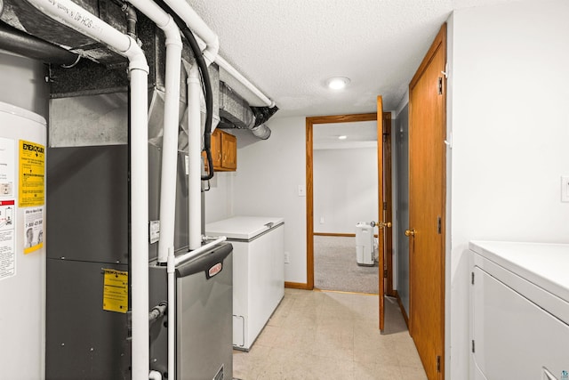 utility room featuring water heater and washing machine and clothes dryer