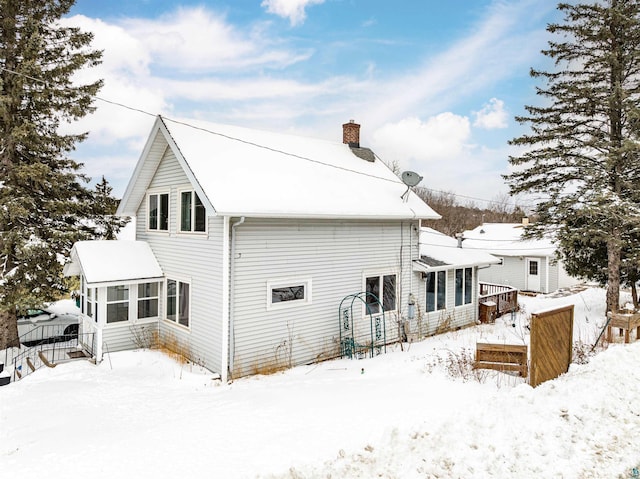 view of snow covered back of property