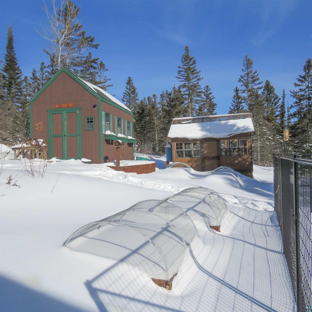 yard covered in snow featuring a storage shed