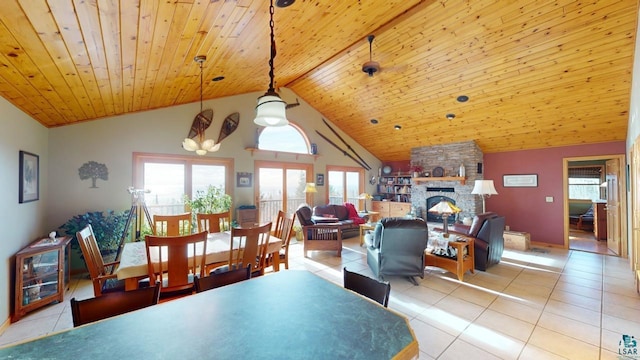 dining space with a stone fireplace, light tile patterned floors, wooden ceiling, and high vaulted ceiling