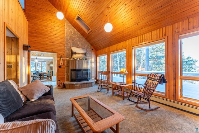 carpeted living room with a fireplace, a wealth of natural light, high vaulted ceiling, and wood walls