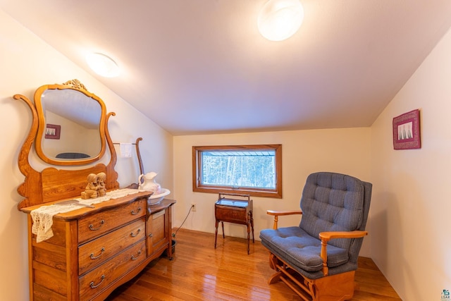 sitting room with lofted ceiling and wood-type flooring