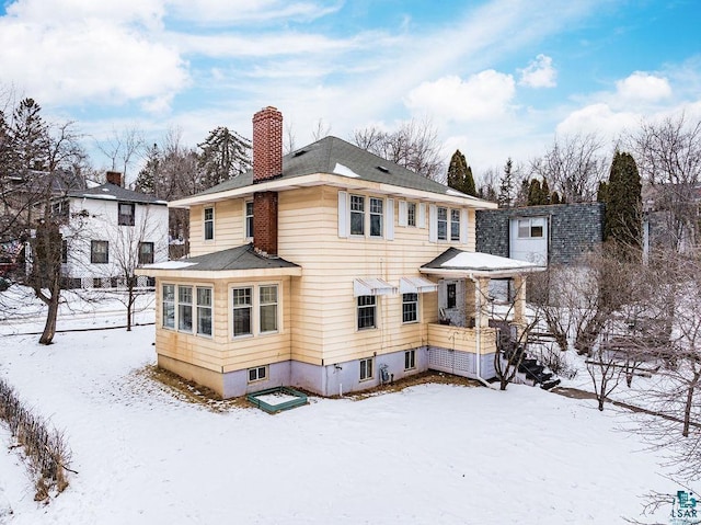 view of snow covered back of property