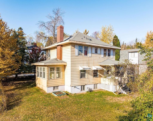 rear view of house featuring a yard