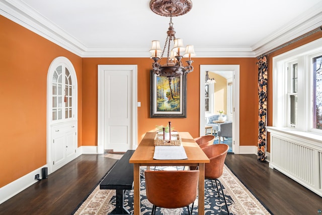 dining area with ornamental molding, radiator, a notable chandelier, and dark hardwood / wood-style floors