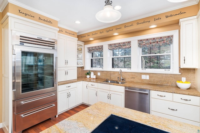 kitchen featuring sink, light stone counters, hanging light fixtures, dishwasher, and oven