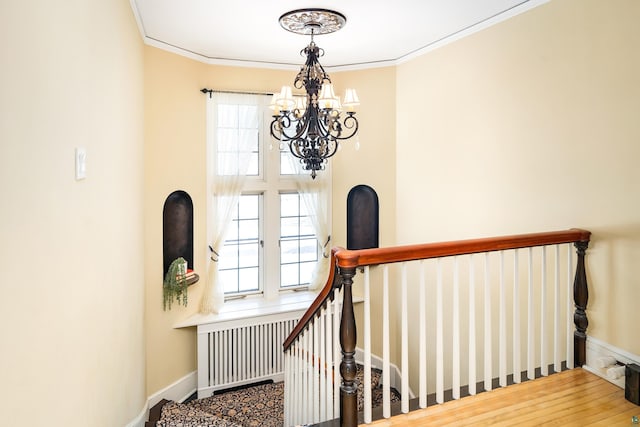 stairway with hardwood / wood-style flooring, ornamental molding, and a healthy amount of sunlight