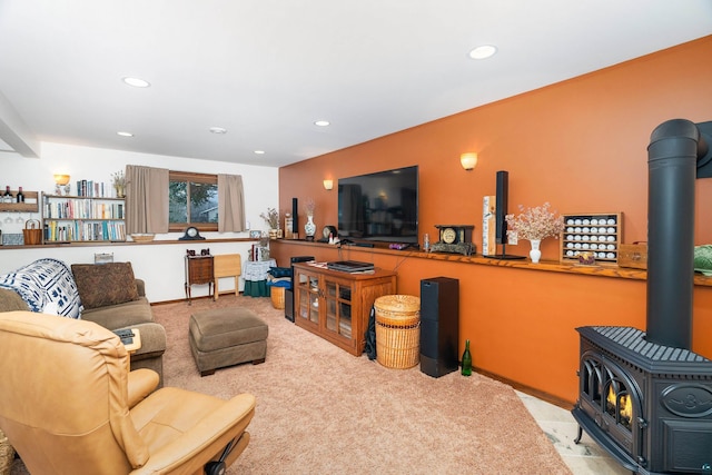 carpeted living room with a wood stove