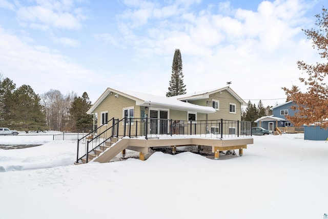 snow covered rear of property featuring a wooden deck