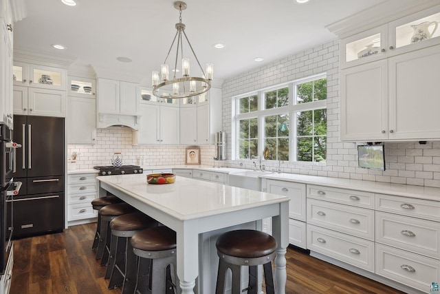 kitchen with white cabinetry, decorative backsplash, a breakfast bar area, and a kitchen island