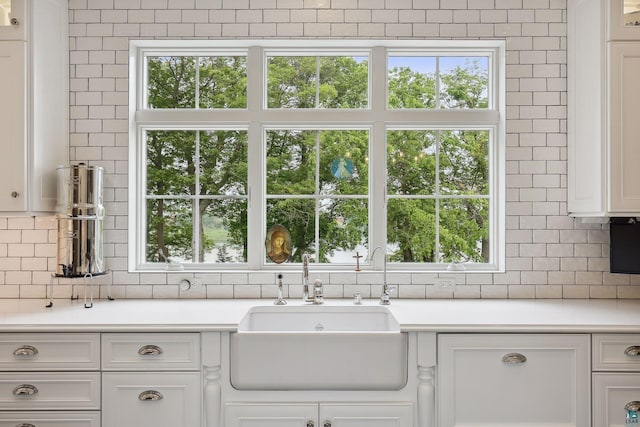 kitchen with white cabinetry, sink, backsplash, and a healthy amount of sunlight