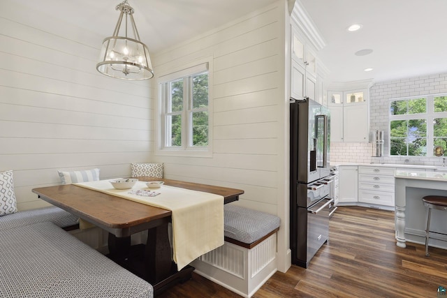 dining room featuring breakfast area, crown molding, dark hardwood / wood-style flooring, and an inviting chandelier