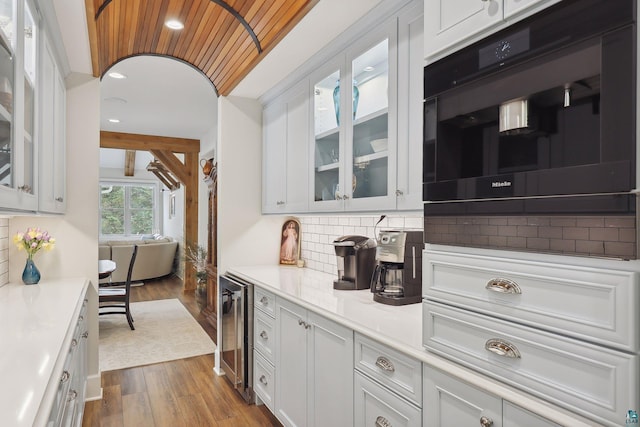 kitchen featuring white cabinetry, backsplash, wine cooler, and light hardwood / wood-style floors