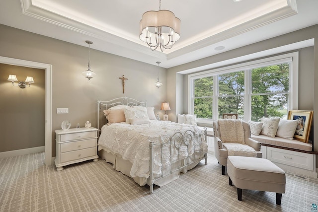 carpeted bedroom featuring a raised ceiling, crown molding, and a notable chandelier