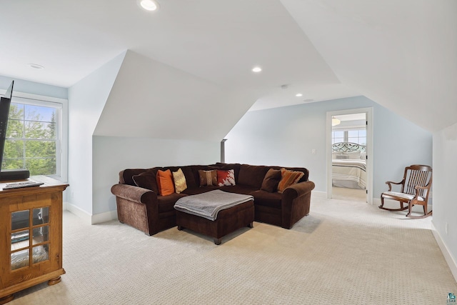 living room with vaulted ceiling, light carpet, and a wealth of natural light