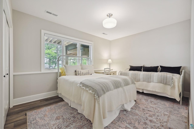bedroom with dark hardwood / wood-style floors