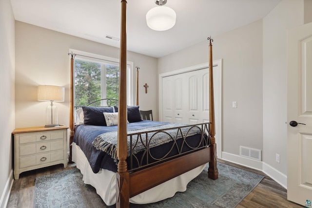 bedroom with dark hardwood / wood-style flooring and a closet