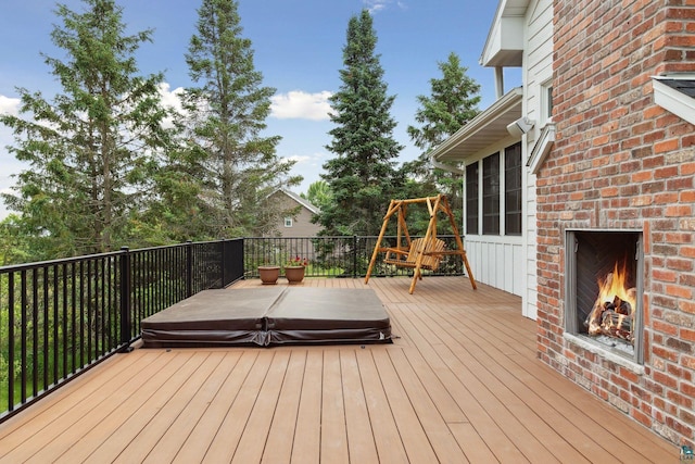 wooden terrace with an outdoor brick fireplace and a playground