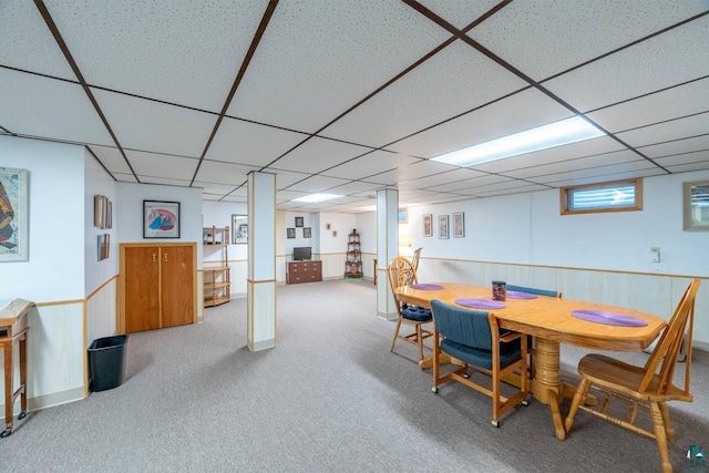 carpeted dining room featuring a paneled ceiling