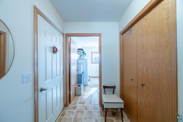 hallway with light tile patterned floors and a textured ceiling