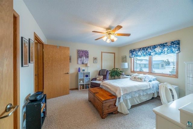 carpeted bedroom with ceiling fan and a textured ceiling