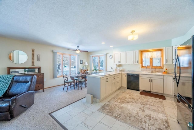 kitchen featuring sink, fridge, kitchen peninsula, dishwasher, and white cabinets