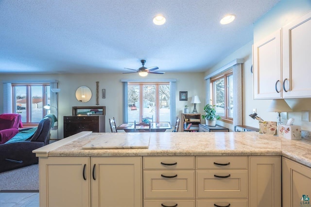 kitchen featuring ceiling fan, kitchen peninsula, and a textured ceiling