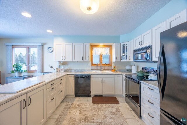 kitchen featuring sink, white cabinets, a textured ceiling, and black appliances