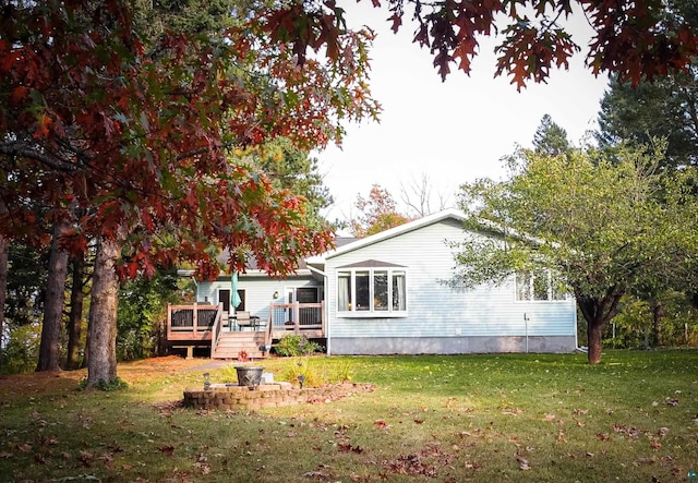 back of property with a yard and a deck